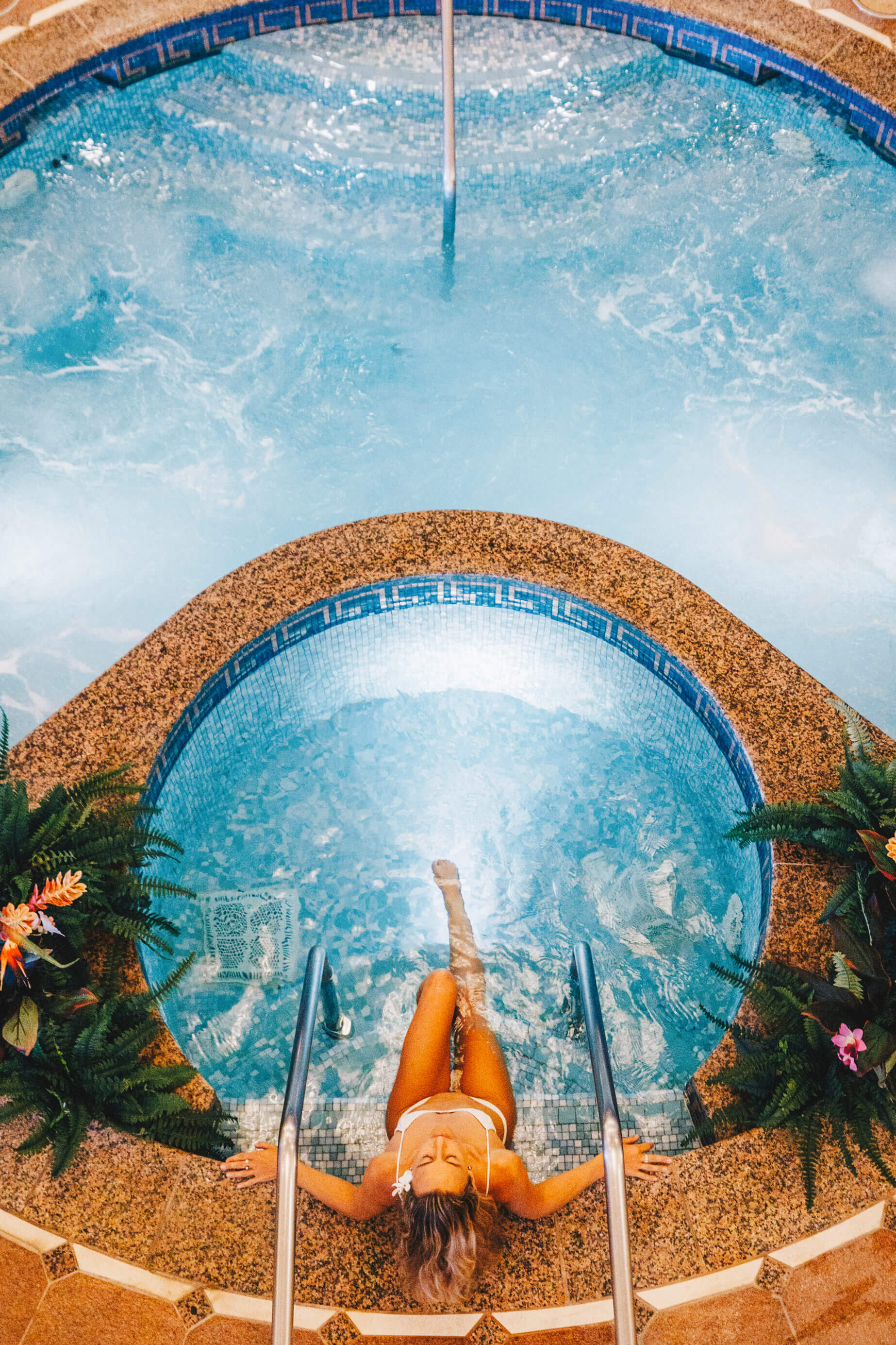 aerial view of woman sitting on the edge of a personal pool 