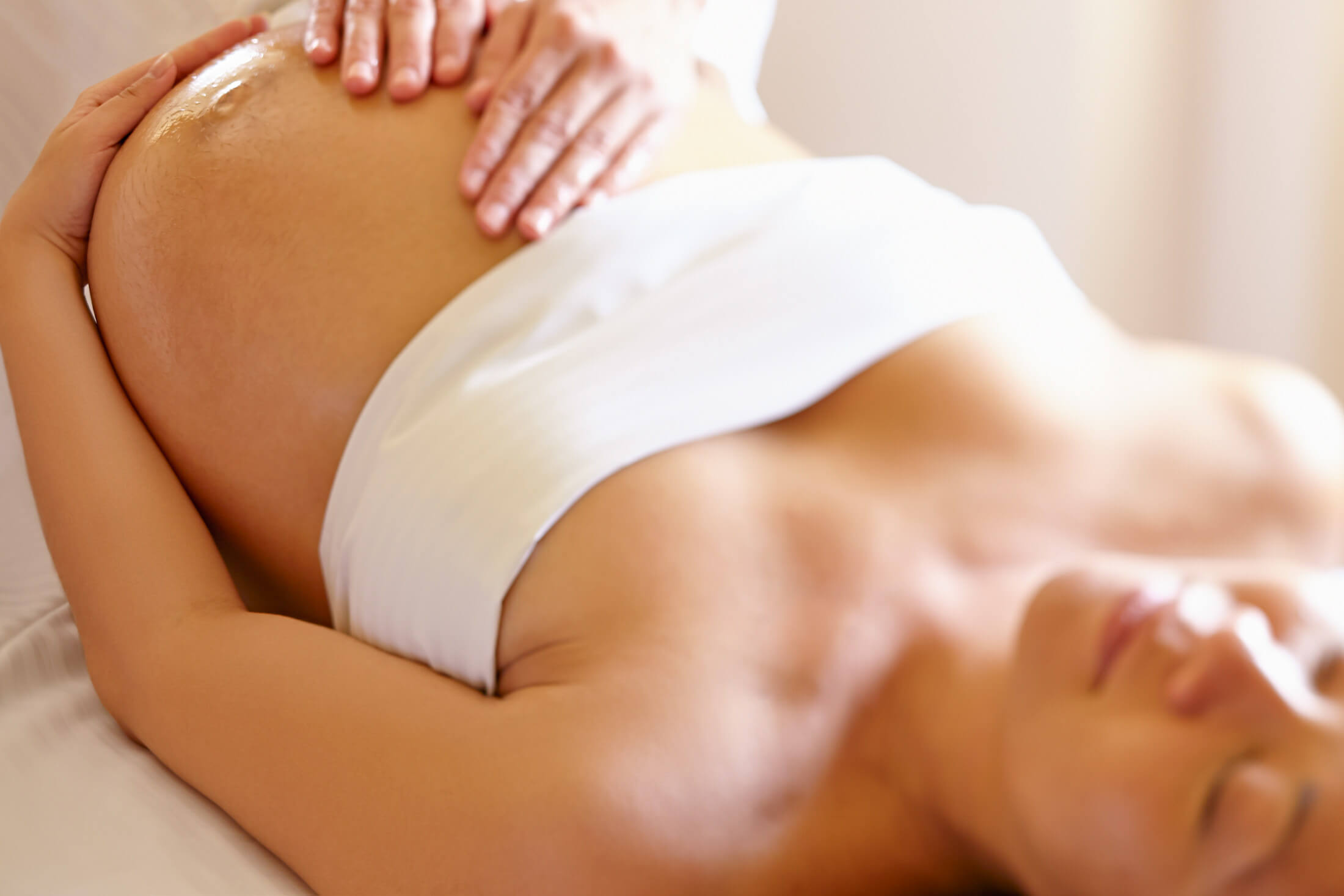 a woman lays on her back while holding her stomach 