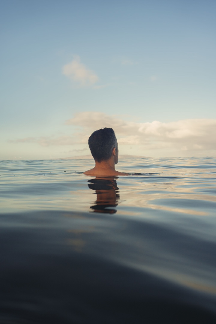 A man floating in the sea with his entire body submerged