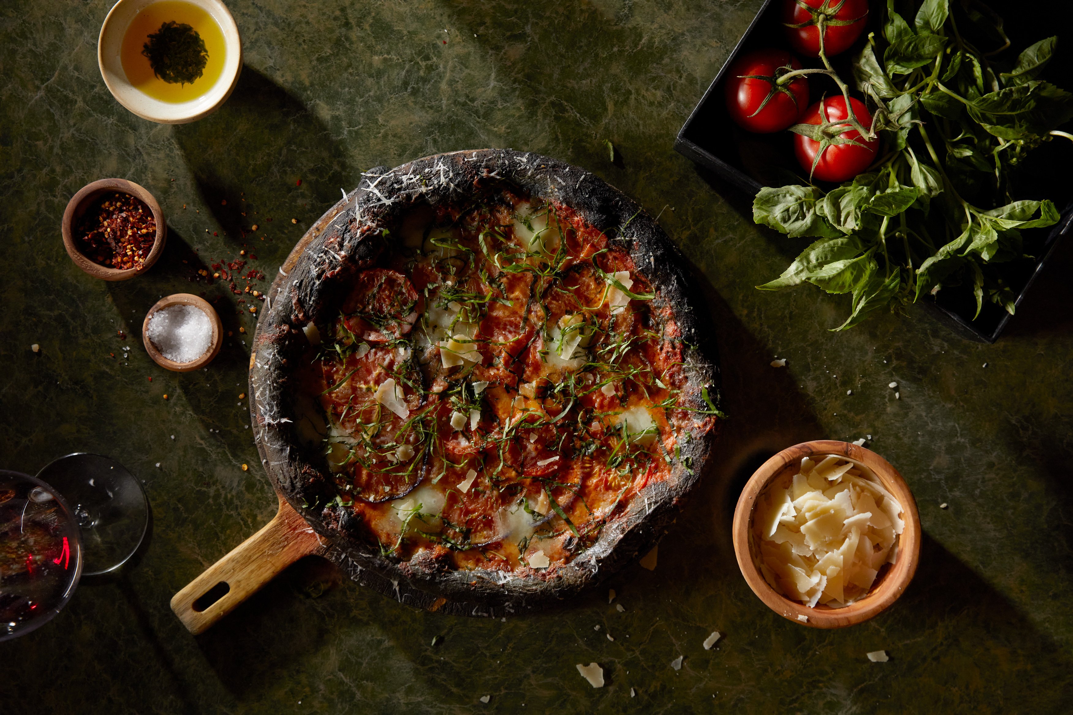 A dish made in a stone skillet with sides and vegetables