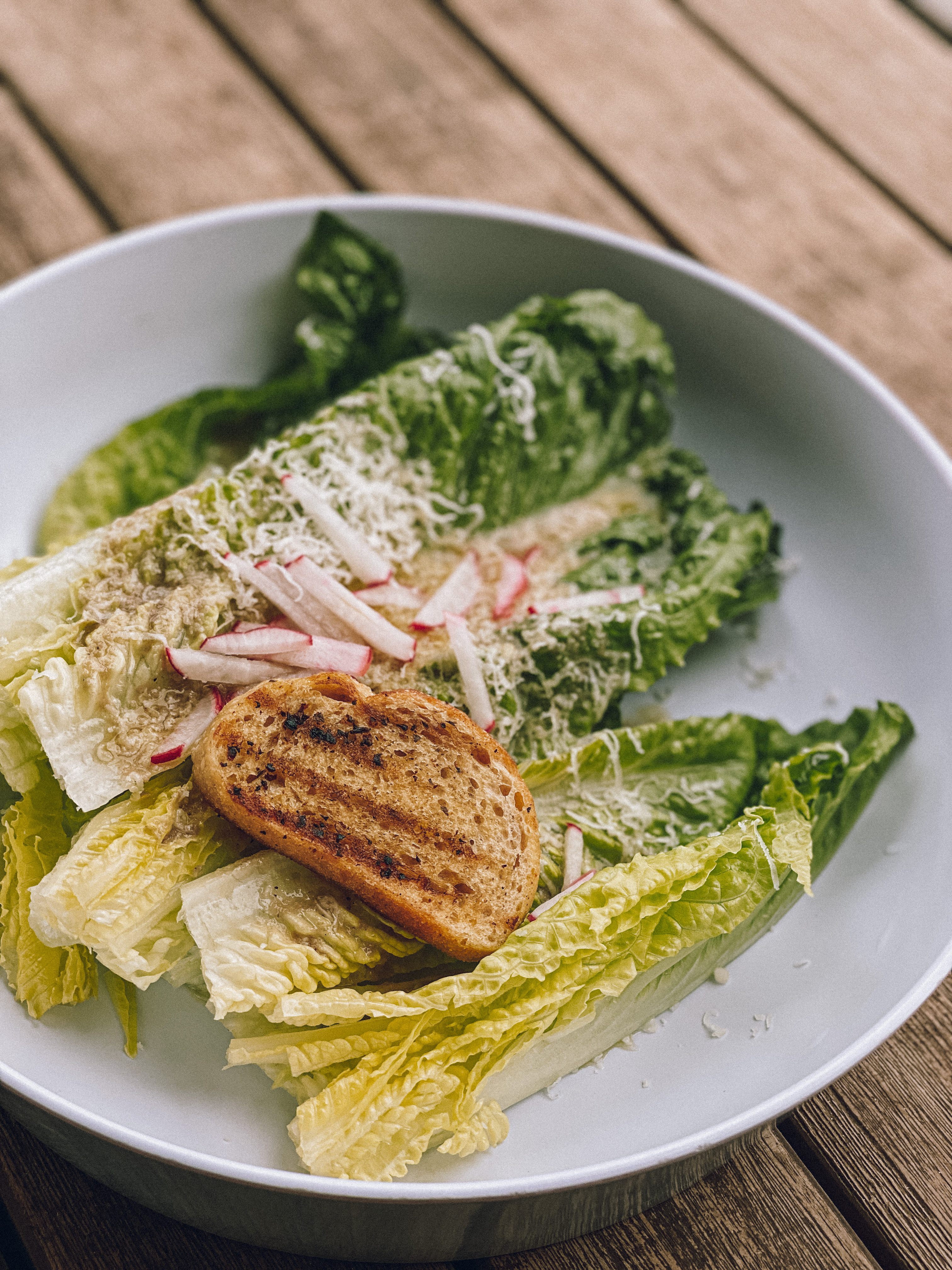 A plate with caesar salad and toasted bread 