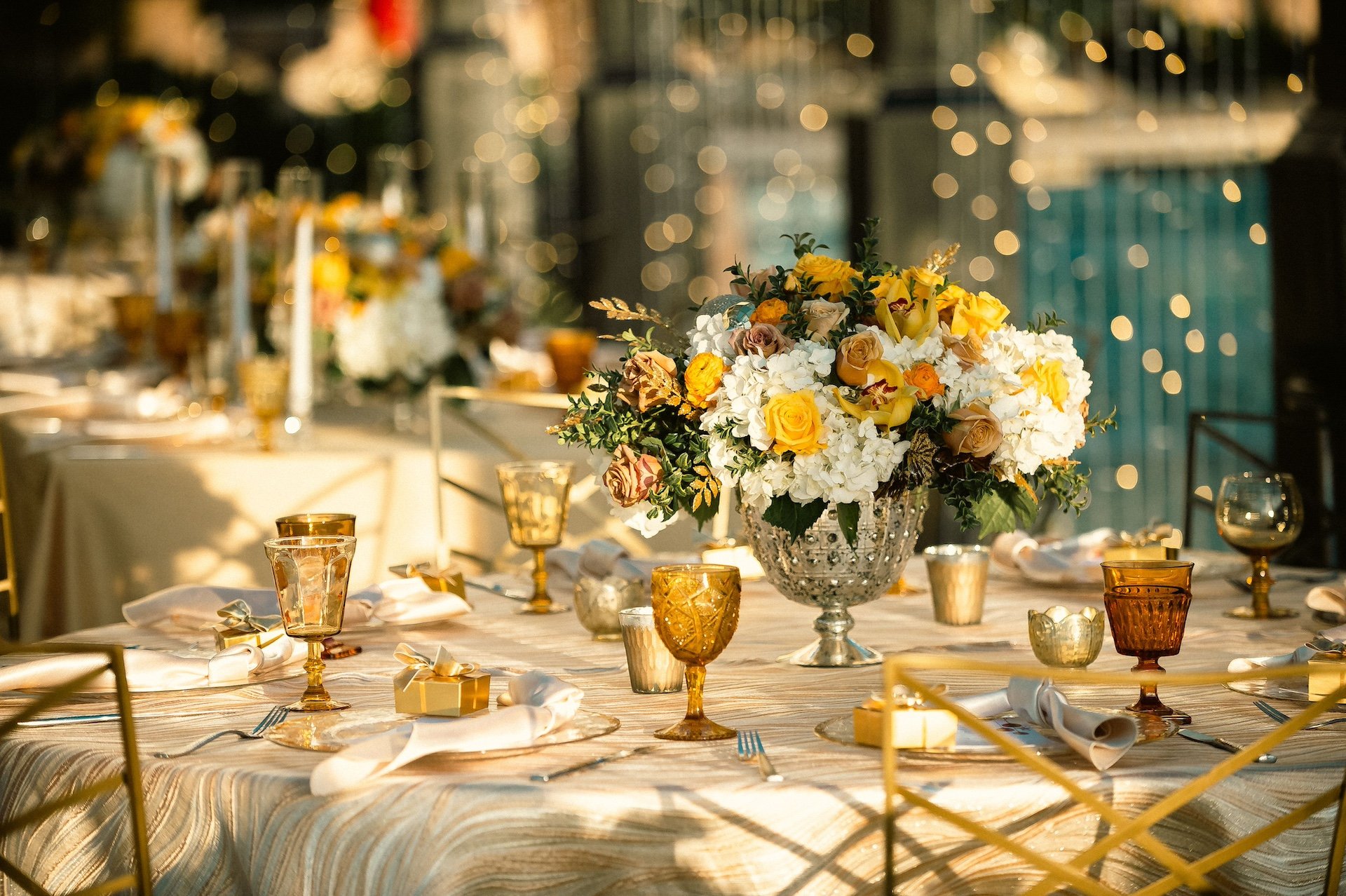 A wedding banquet table with a yellow and white flower bouquet