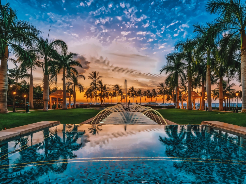 view of the Grand Wailea resort and pool with a dark blue and orange sky