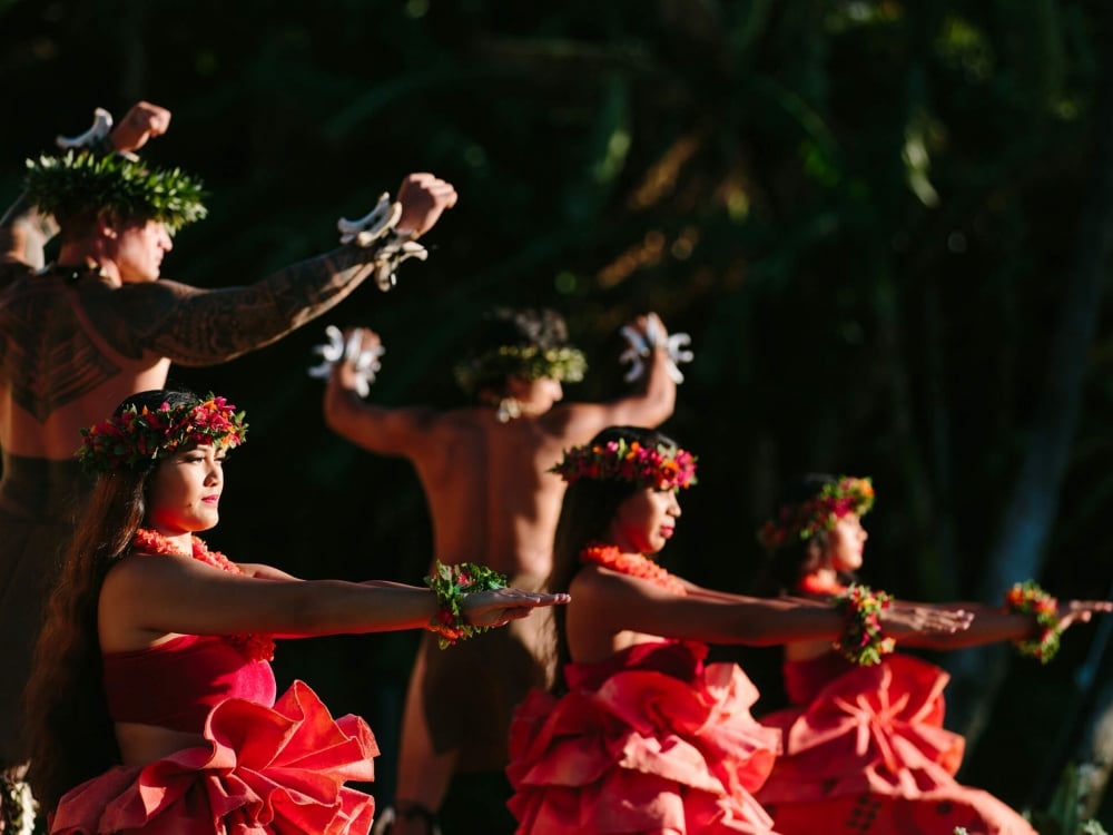 a group of women in red and men dance on a stage