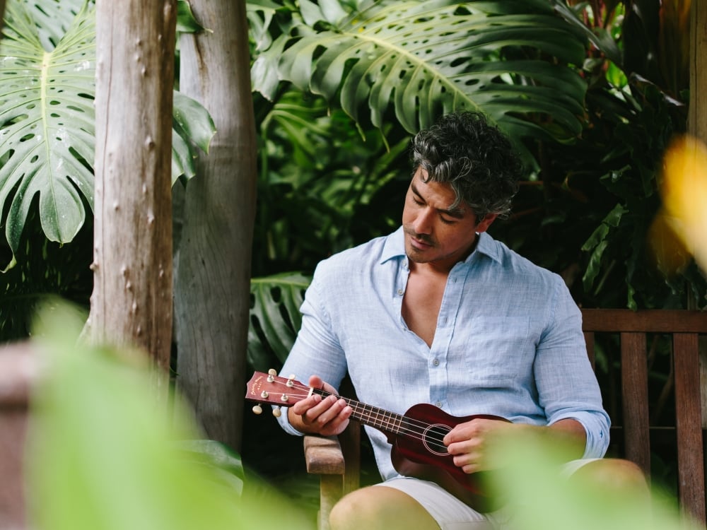 Man playing ukulele in the garden 