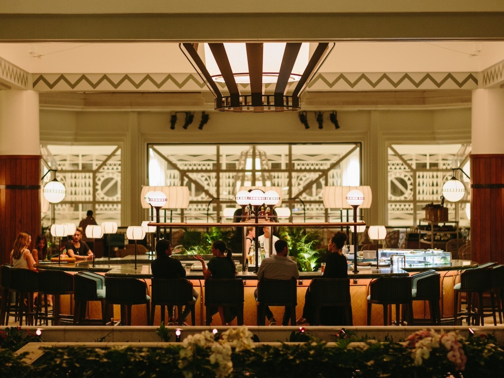 A large restaurant dining room with large communal tables and wide windows