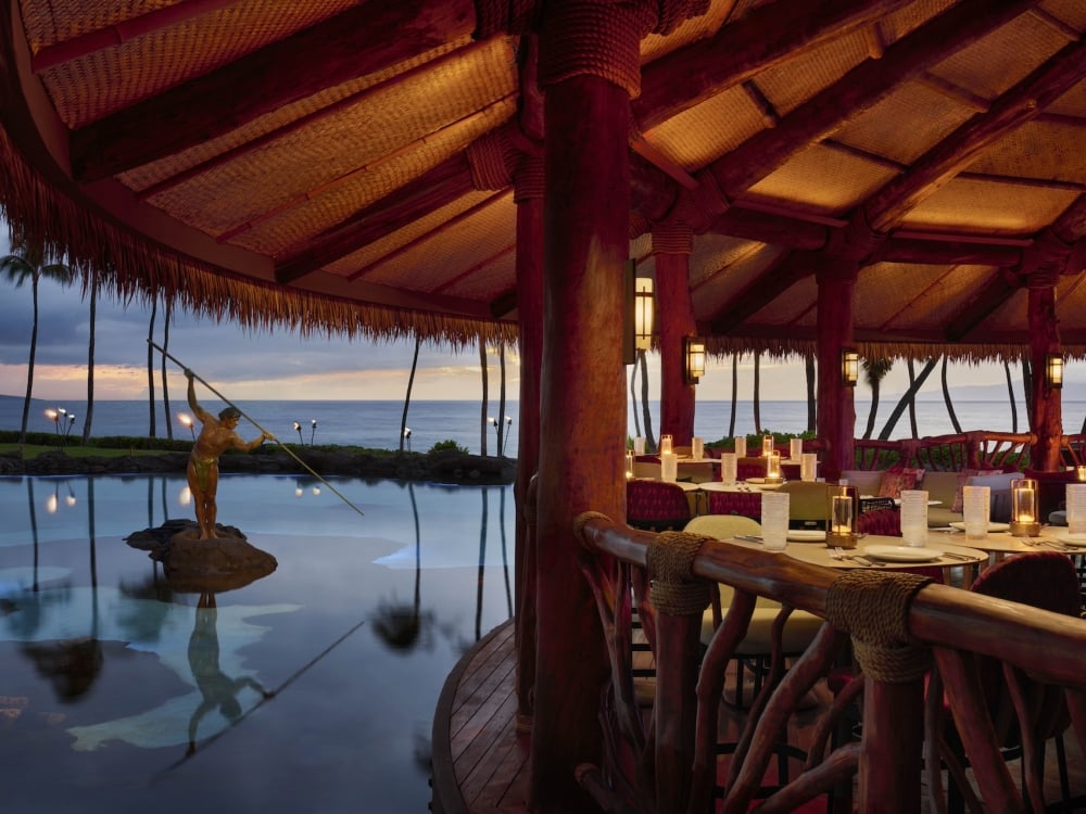 An oceanside patio, next to a statue, at dusk