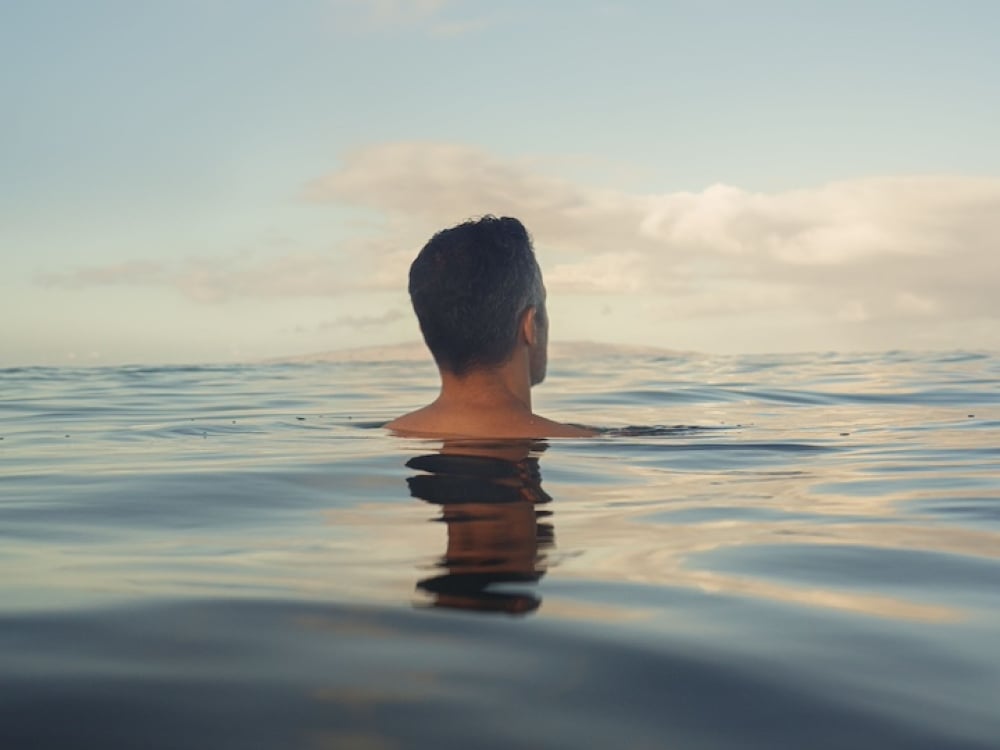 A man floating in the sea with his entire body submerged