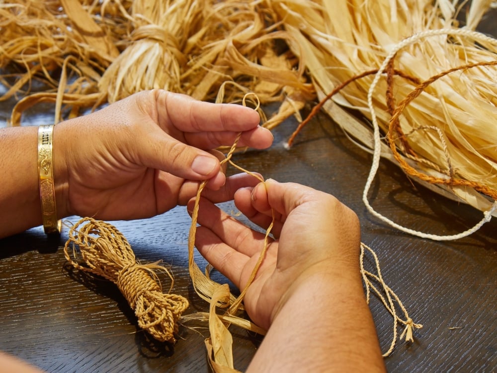 A person weaving a Pipipi bracelet