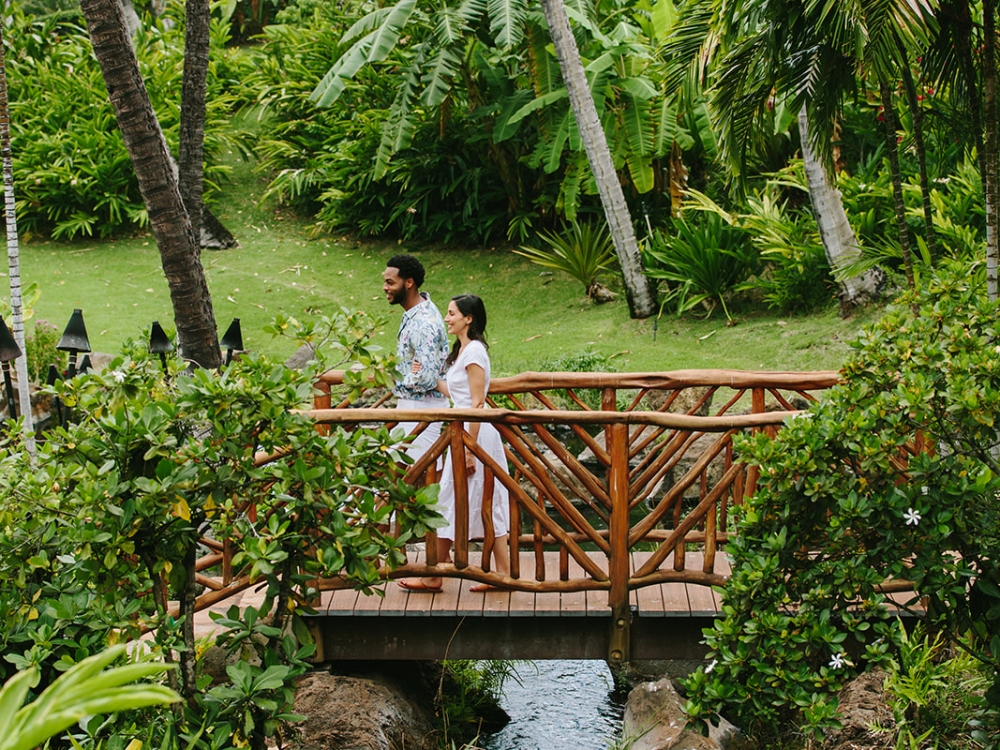 couple walking over a small wooden bridge