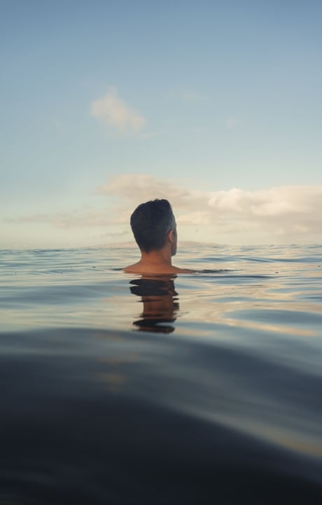 A man floating in the sea with his entire body submerged