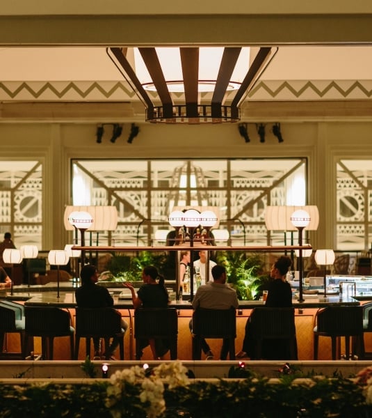 A large restaurant dining room with large communal tables and wide windows