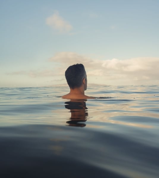 A man floating in the sea with his entire body submerged