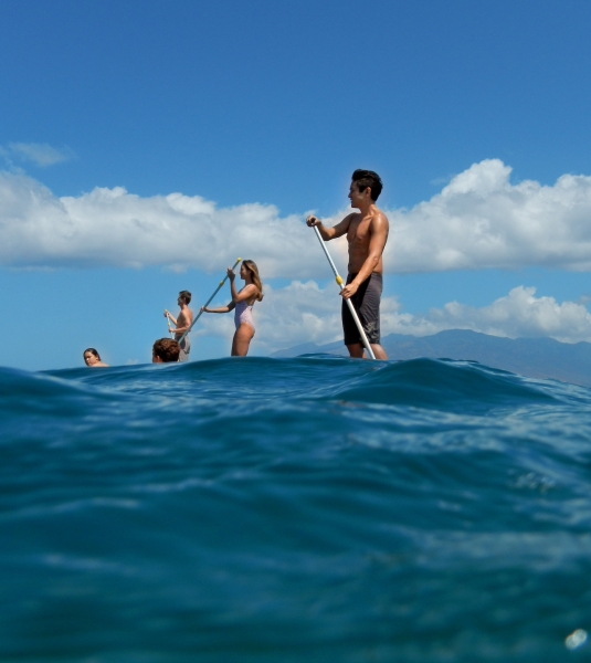 Paddle boarders on blue waves