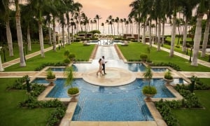 couple walk through pool area of Grand Wailea resort at sunset