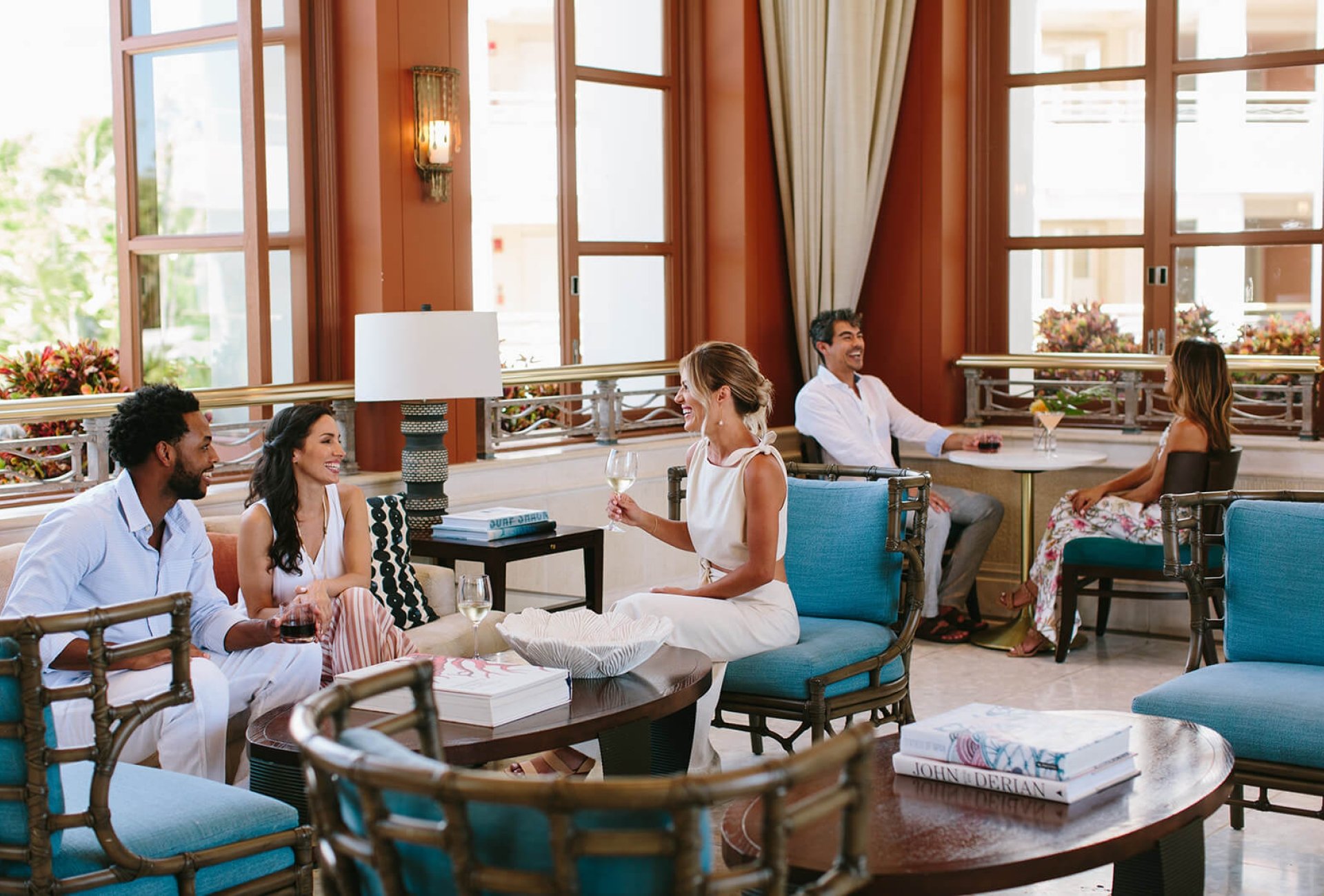 a group of people sit on comfortable lounge seating facing each other in a large open room 