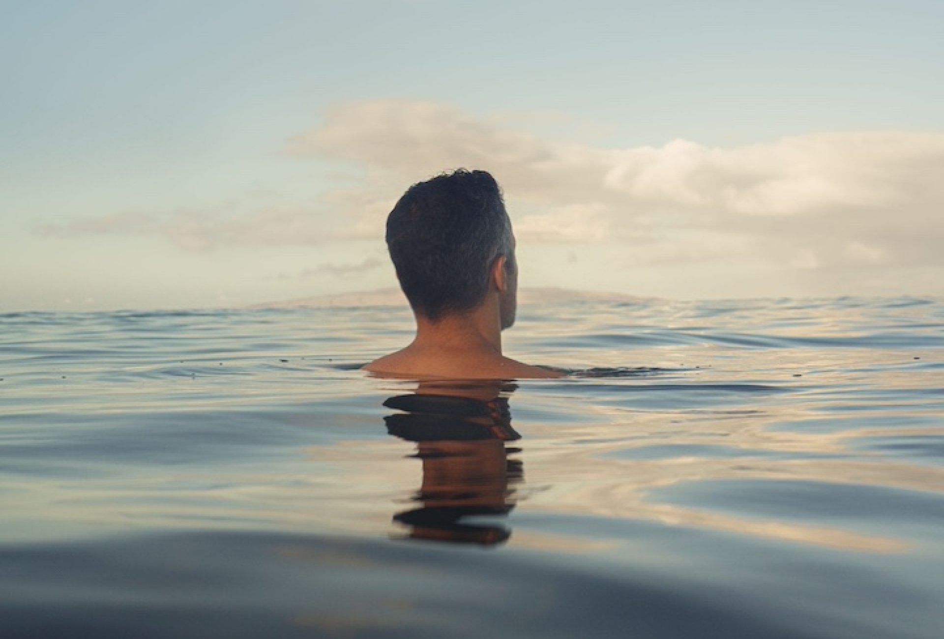 A man floating in the sea with his entire body submerged