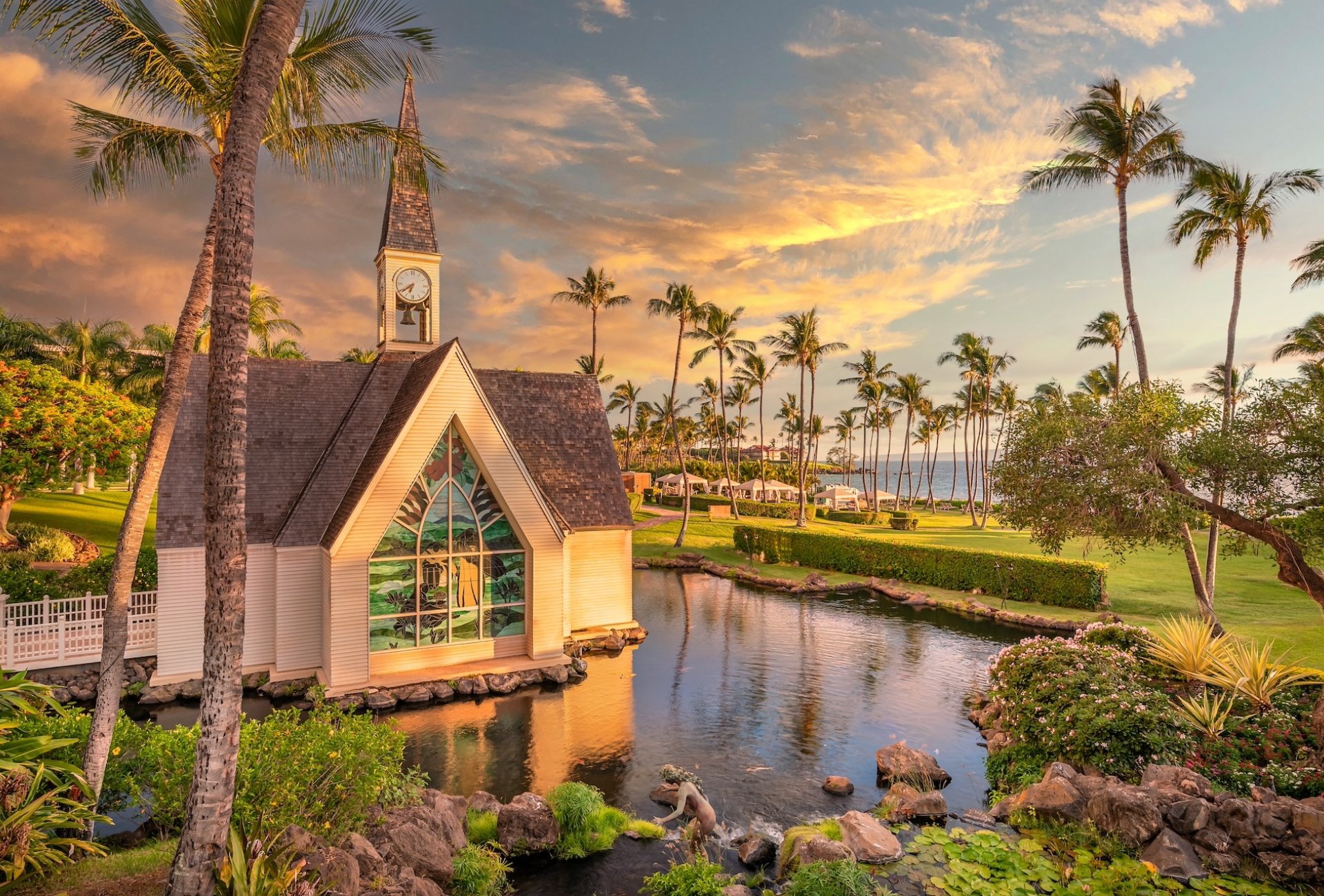 A small chapel in a garden lined with palm trees