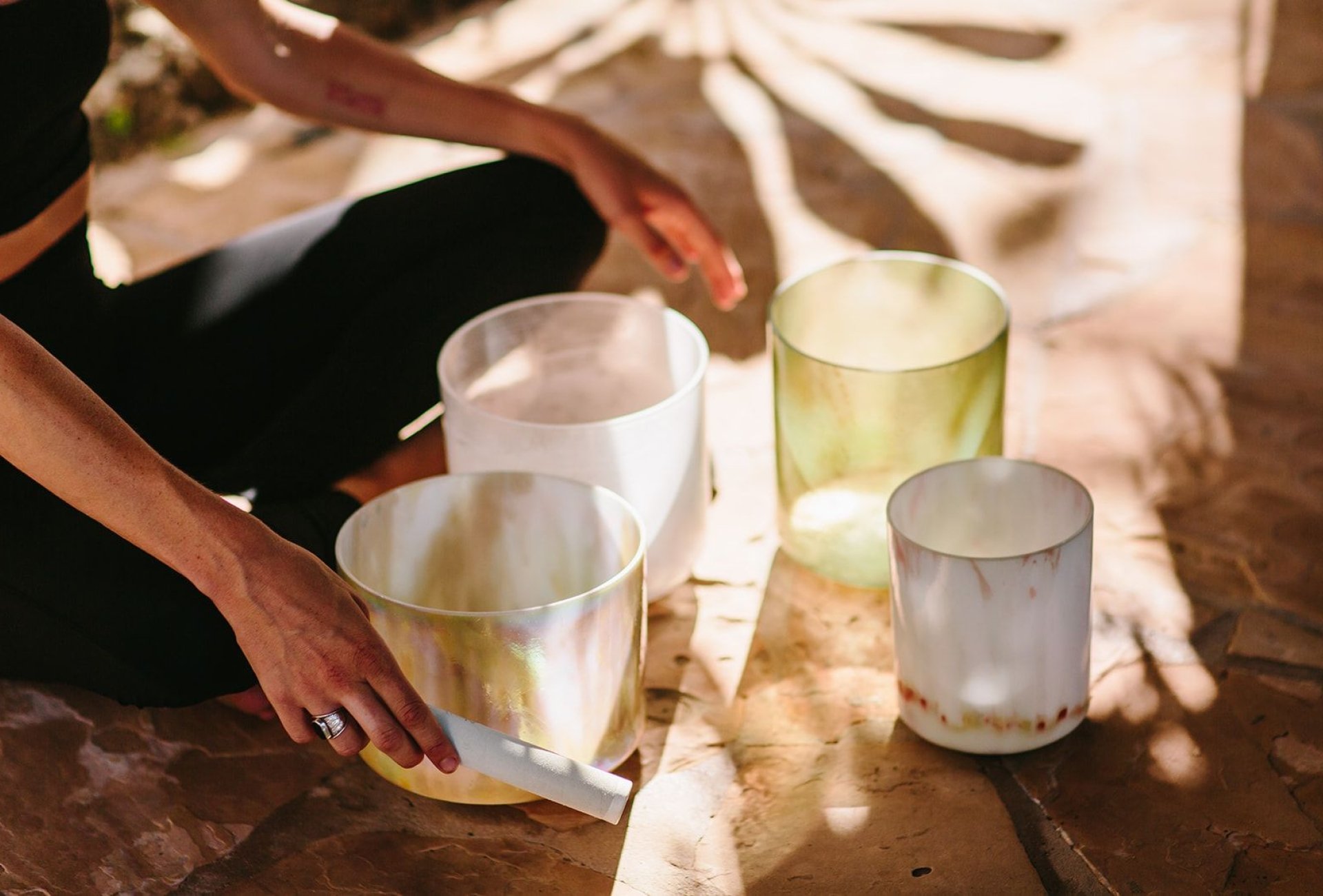 A person using sound therapy bowls